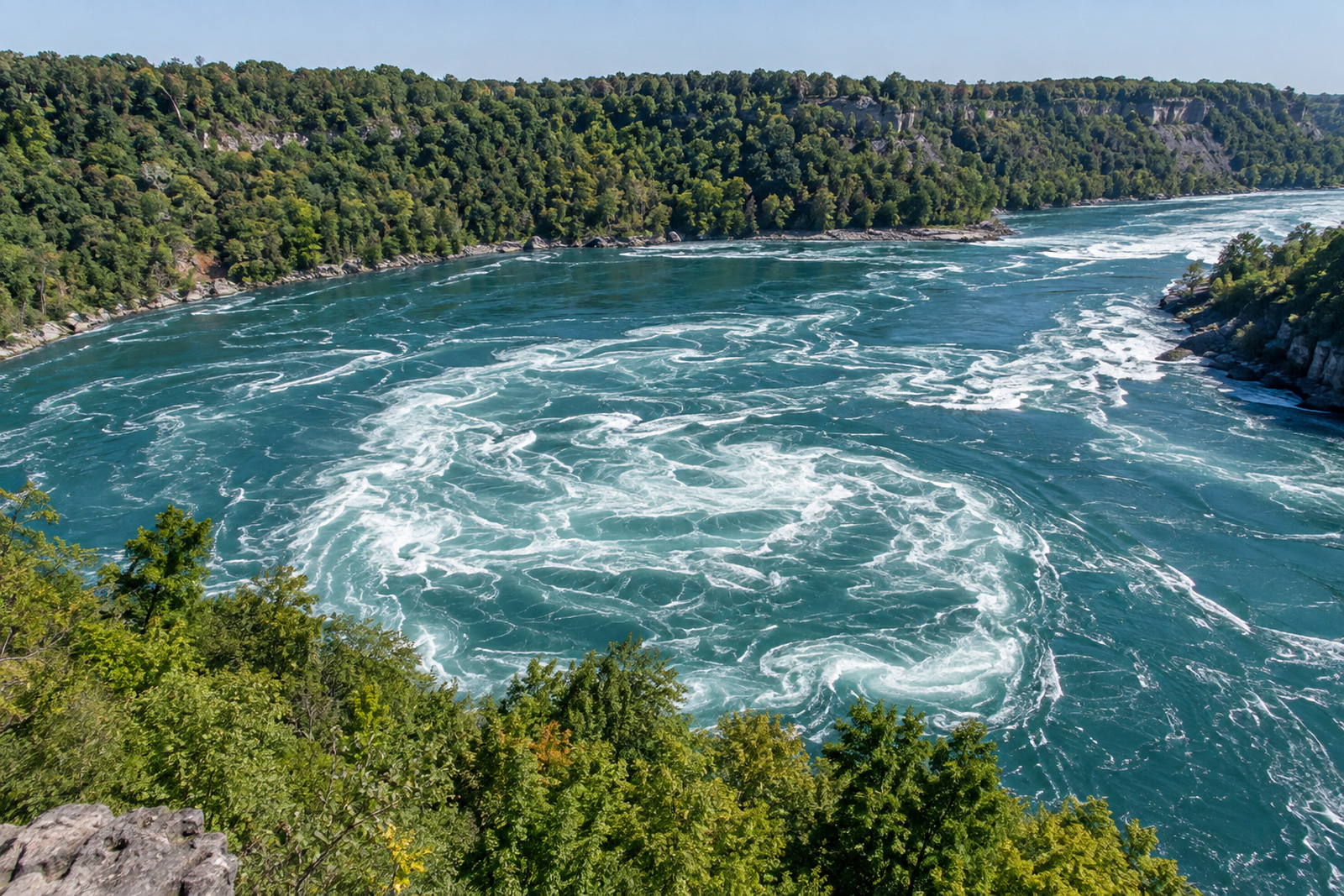 The red cable car cabin suspended over the swirling water of the Niagara Whirlpool